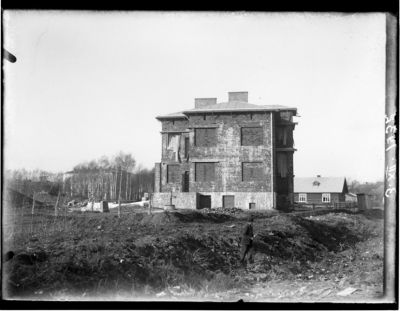 Zdjęcie z budowy willi Fryderyka Janusza, obecnie siedziby Estrady Rzeszowskiej przy ul. Jagiellońskiej 24, wykonane 3 grudnia 1932 roku. Fotografia przedstawia budynek jeszcze w stanie surowym. W tle widoczny drewniany dom, który obrazuje, w jak tradycyjnej i skromnej zabudowie przedmieścia miały miejsce pierwsze próby unowocześniania pejzażu architektonicznego miasta. Zdjęcie ze zbiorów Galerii Fotografii Miasta Rzeszowa